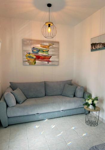 a couch in a living room with a painting on the wall at Murter Inn in Murter