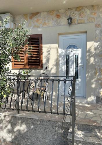 two benches in front of a house with a door at Murter Inn in Murter