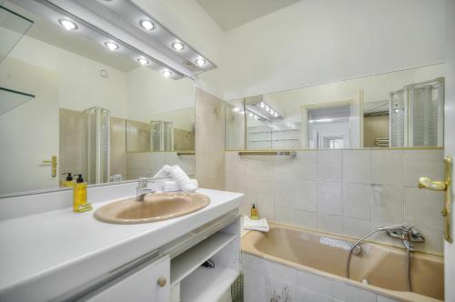 une salle de bain avec un lavabo et un grand miroir dans l'établissement Immogroom - large apartment clim/terrace - wifi, à Cannes