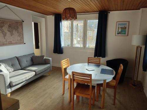 un salon avec une table, des chaises et un canapé dans l'établissement Appart Le Crotoy Bécassine 50mètres Plage,centre., au Crotoy