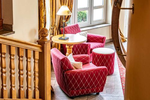 a room with two chairs and a table and a lamp at Schloss Hotel Holzrichter in Nachrodt-Wiblingwerde