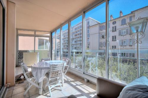 d'un balcon avec une table, des chaises et des fenêtres. dans l'établissement Immogroom - large apartment clim/terrace - wifi, à Cannes