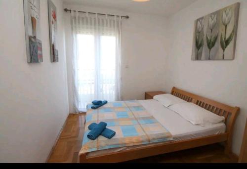 a bedroom with a bed with blue bows on it at Sea & Mountain View Apartment in Budva