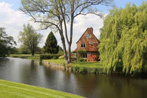 a house sitting on the side of a river at Talbooth House & Spa in Dedham