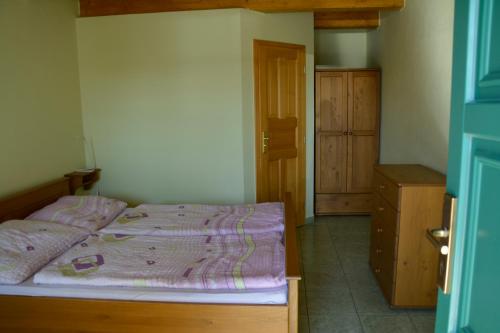 a bedroom with a bed with a purple comforter at Vinařský dům Sedlec in Sedlec