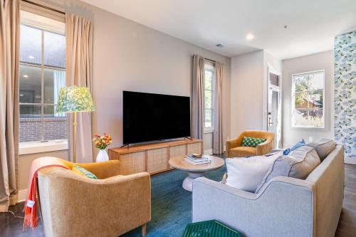 a living room with two chairs and a television at The Magnolia by AvantStay in Nashville