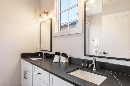 a bathroom with two sinks and a large mirror at The Magnolia by AvantStay in Nashville