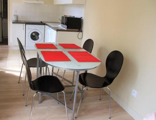 - une table et des chaises dans une cuisine avec lave-linge dans l'établissement La Caravelle, à Châtelaillon-Plage