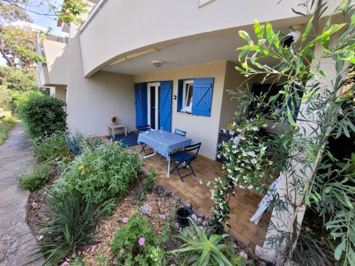 une maison avec un banc bleu sur une terrasse dans l'établissement T2, Piscine en saison, Terrasse, Plage, parc privé, au Lavandou