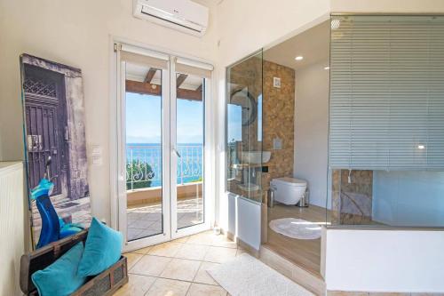 y baño con ducha y vistas al océano. en Villa Seawave by Villa Plus, en Agios Spiridon, Corfú