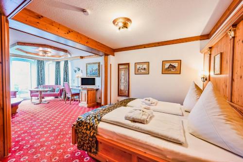 a bedroom with a large bed and a living room at Schloss Hotel Holzrichter in Nachrodt-Wiblingwerde