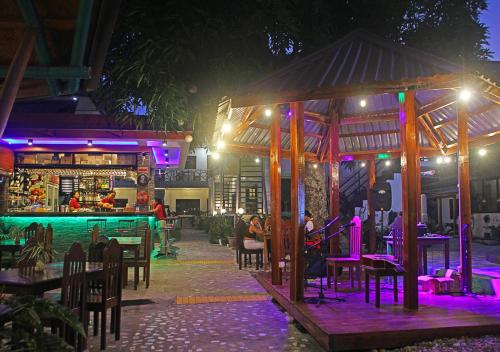 a restaurant with tables and a bar at night at Hotel Oasis Port Barton in San Vicente