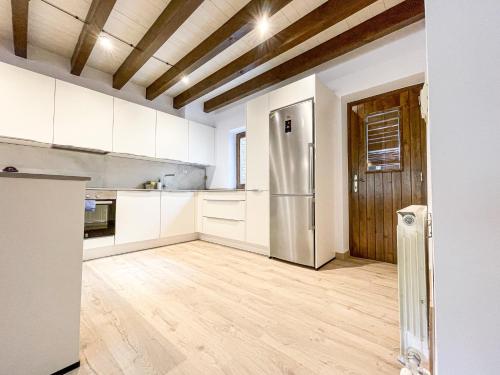 a kitchen with white cabinets and a stainless steel refrigerator at Encant muntanyès, casa amb vistes a Martinet in Martinet