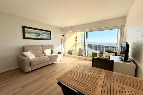 un salon avec un canapé, une table et une télévision dans l'établissement Studio - Face à la mer - Vue 180, à Quiberon