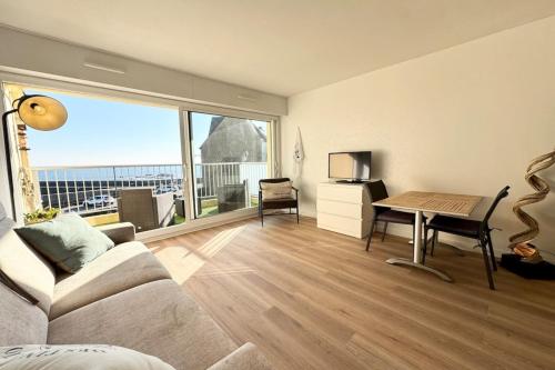 un salon avec un canapé et une table dans l'établissement Studio - Face à la mer - Vue 180, à Quiberon
