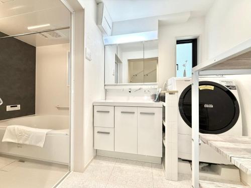 Un baño con lavabo y lavadora. en Katsushika House柴又, en Tokio