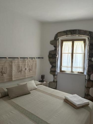 a bedroom with a large bed and a window at B&B Pudzones in Santu Lussurgiu