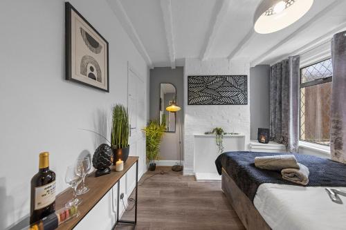 a bedroom with a bed and a bottle of wine at Cosy 3-bed House Free Parking and Hot tub in Chatham