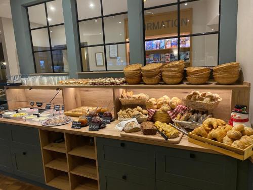 a bakery counter with various types of bread and pastries at Hotel Wernerwald in Cuxhaven