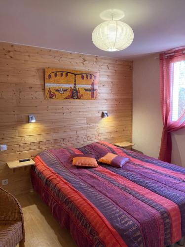 l'ESCALE في سان-بير-سور-مير: غرفة نوم بسرير كبير مع جدار خشبي