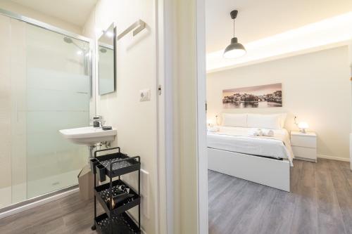 bagno bianco con letto e lavandino di Lumen - Downtown Vibes a Cagliari