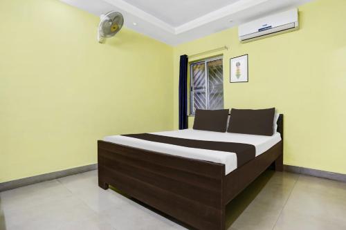 un letto in una camera con pareti verdi di Hotel O Grand Occasion a Rānchī