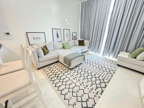 a white living room with a couch and a rug at Dubai damac hills luxurious appartment in Dubai
