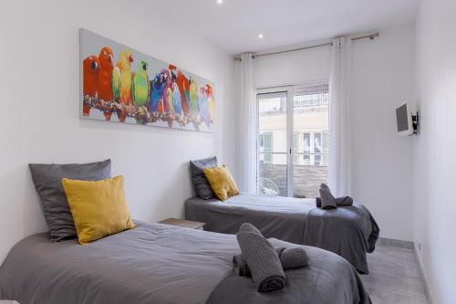 une chambre avec deux lits et un tableau au mur dans l'établissement 38 Meynadier 4p by Halldis, à Cannes