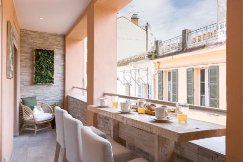 un balcon avec une table, des chaises et une fenêtre dans l'établissement 38 Meynadier 4p by Halldis, à Cannes