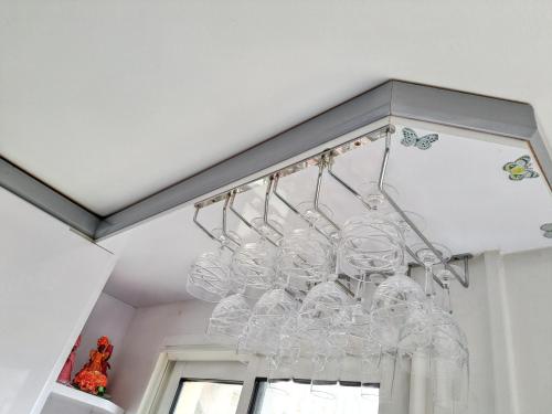 a chandelier with wine glasses hanging from a ceiling at Studio de charme à Bouillante, 100 m², vue sur mer et montagnes in Bouillante
