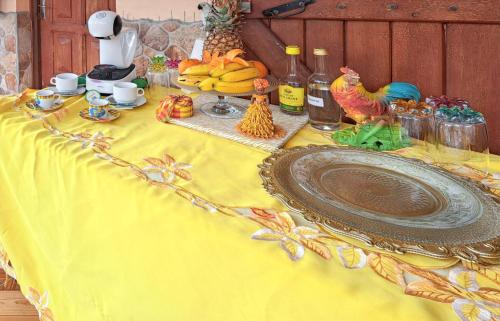 a table with a yellow table cloth with a plate of food at Studio de charme à Bouillante, 100 m², vue sur mer et montagnes in Bouillante