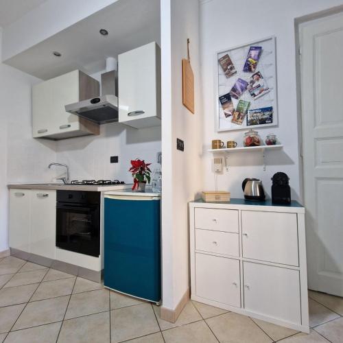 a kitchen with white cabinets and a blue refrigerator at Casa Gran Madre in Turin