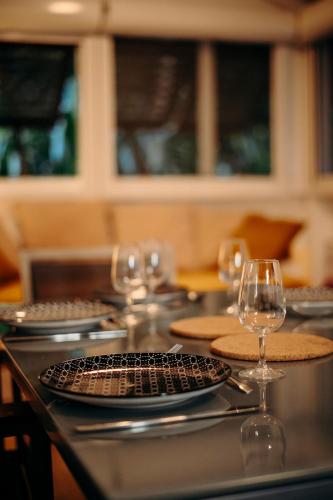 a table with plates and wine glasses on it at Bungalow et Duplex de Island Bay in Bouillante