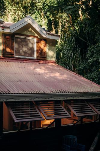 a house with a rusty tin roof with a window at Bungalow et Duplex de Island Bay in Bouillante