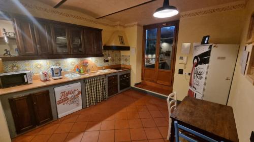 a kitchen with a refrigerator and a table in it at La Menchina ( Alloggio privato) in Arezzo