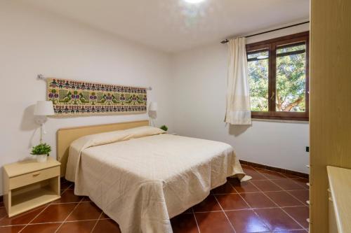 a bedroom with a bed and a window at Residenza Melissa, appartamenti in Jerzu