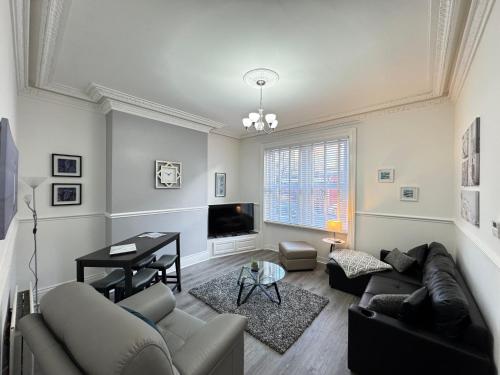 a living room with a couch and a tv at Station Retreat Cullercoats Free Onsite Parking in Cullercoats