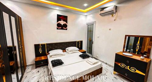 a bedroom with a bed and a television in a room at Résidence Mounir in Thiès