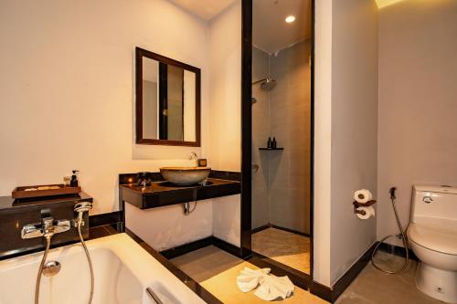 a bathroom with a tub and a sink and a toilet at Malabar Pool Villa Phuket in Phuket Town