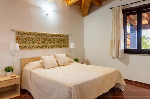 a bedroom with a bed and a window at Residenza Melissa, appartamenti in Jerzu