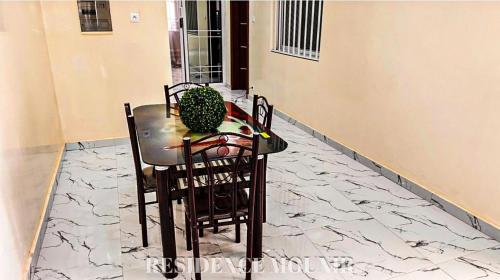 a table with chairs and a plant on top of it at Résidence Mounir in Thiès