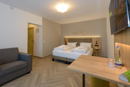 a hotel room with a bed and a couch at BERGlässig Hotel Bodenmais - 360 Grad Urlaub in Bodenmais