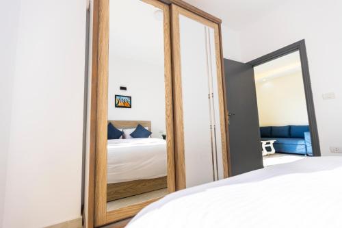 a bedroom with a large mirror in front of a bed at Lazur Pool Apartment's - El Kawsar, Hurghada - Egypt in Hurghada