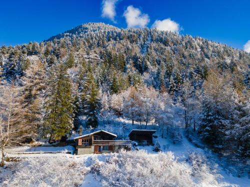 a house in the snow in front of a mountain at Charmant Chalet dans la montagne proche de Verbier in Sembrancher