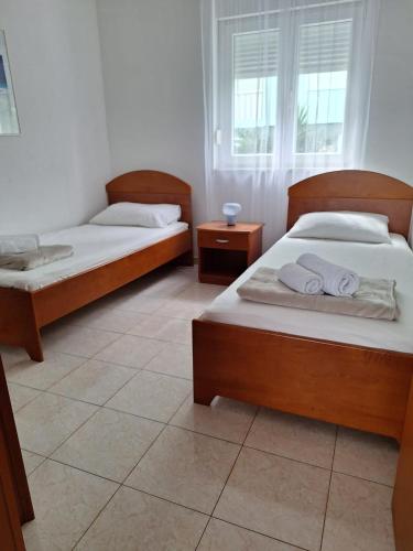 a bedroom with two beds and a window at Apartman Fishers View in Trogir