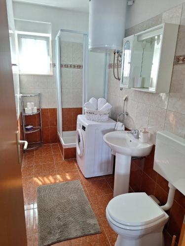 a bathroom with a toilet and a sink and a shower at Apartman Fishers View in Trogir