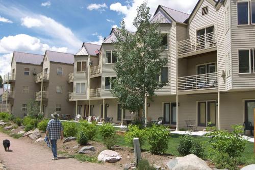 a man walking a dog in front of a building at Viking Lodge 103 by AvantStay Stunning Condo Near Ski Lift in Telluride