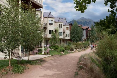 a street with houses and people walking down a dirt road at Viking Lodge 103 by AvantStay Stunning Condo Near Ski Lift in Telluride