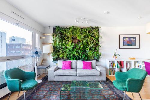 - un salon avec un canapé et un mur vert dans l'établissement GuestReady - Charming stay near Chinatown, à Paris