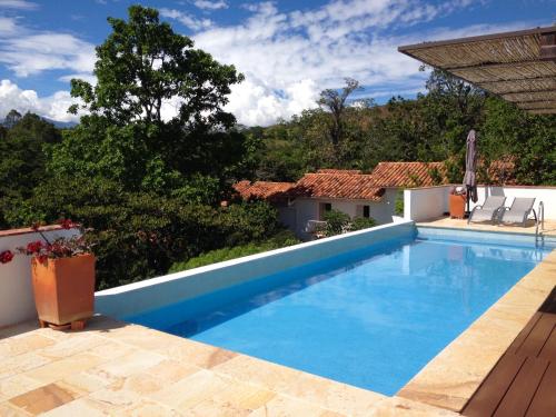 a swimming pool in front of a house at Hotel Alto Del Viento in Barichara